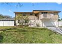 Inviting home with a balcony, white picket fence, and manicured landscaping at 412 Manor Blvd, Palm Harbor, FL 34683