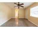 Inviting bedroom showcasing a ceiling fan, view of hallway and speckled flooring at 4323 S Lois Ave, Tampa, FL 33611