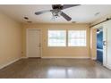 Spacious bedroom featuring two windows, ceiling fan, barn door and speckled flooring at 4323 S Lois Ave, Tampa, FL 33611