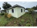 Corner of light green house with decorative window bars and overgrown plants at 4920 S 82Nd St, Tampa, FL 33619