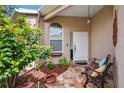 Inviting front porch area with seating and flowering plants, perfect for relaxing at 5143 Lochmead Ter, Zephyrhills, FL 33541