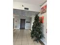 Lobby with tile flooring, high ceilings, artwork, elevator, and holiday Christmas tree at 701 S Madison Ave # 410, Clearwater, FL 33756