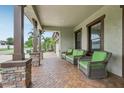 Inviting front porch featuring comfortable seating, brick flooring, and decorative columns offering a cozy outdoor space at 808 Vittorio Pl, Brandon, FL 33511