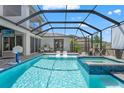 Inviting screened-in pool and spa with poolside seating, perfect for outdoor entertaining at 8752 Loft Pt, Wesley Chapel, FL 33545