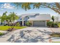 Beautiful home with a two-car garage and a brick-lined driveway surrounded by a lush lawn at 9011 Baywood Park Dr, Seminole, FL 33777