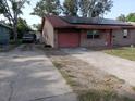 This single-story brick home has a driveway, garage, solar panels, and is surrounded by trees at 902 Marshall St, Clearwater, FL 33755