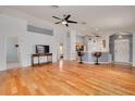 Open-concept living room with hardwood floors, high ceilings, ceiling fans, and a view of the kitchen bar at 11078 Heathrow Ave, Spring Hill, FL 34609