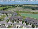 An aerial view of townhomes next to a large field, pond and view of the neighborhood at 11287 Cay Spruce Way, San Antonio, FL 33576