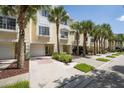 Townhome exterior showing attached garage, neutral color scheme, and a palm-tree-lined street at 115 Brent Cir, Oldsmar, FL 34677