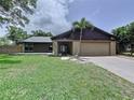 Lovely home with beautiful landscaping, a two-car garage, and a welcoming front entrance at 11525 Country Oaks Dr, Tampa, FL 33618