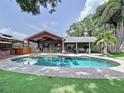 Gorgeous backyard pool area with outdoor bar and covered patio, perfect for entertaining guests at 11525 Country Oaks Dr, Tampa, FL 33618