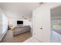 Bright living room featuring wood-look floors, a comfortable gray sofa, and plenty of natural light at 13013 Sawmill Way, Hudson, FL 34667