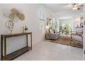 Bright living room with neutral decor, tile flooring, a cozy sofa, and stylish decorative accents at 17592 Nectar Flume Dr, Land O Lakes, FL 34638
