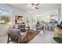 Open-concept living room with white walls, tile floors, ample seating, and a glimpse into the modern kitchen at 17592 Nectar Flume Dr, Land O Lakes, FL 34638