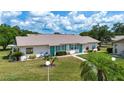 Attractive home with a well-manicured lawn, lush landscaping, and a welcoming walkway at 1906 Canterbury Ln # 20, Sun City Center, FL 33573