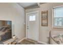 Bright entryway featuring a white door with glass panes, stylish decor, and light wood floors at 2018 Windsor Way, Tampa, FL 33619