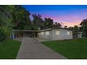 Charming single-story home with a cozy carport and well-maintained lawn at dusk at 2018 Windsor Way, Tampa, FL 33619