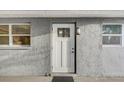 Inviting entryway with a white front door, textured wall, and stylish exterior light fixture at 2018 Windsor Way, Tampa, FL 33619