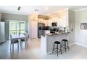 Well-lit kitchen featuring white cabinetry, stainless appliances and breakfast bar at 2190 Great Sapphire Ln, Lutz, FL 33558