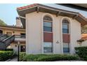 Exterior view of a well-maintained condo building with arched windows and lush landscaping at 2640 Enterprise E Rd # B25, Clearwater, FL 33759