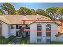 Charming condo with a red tile roof, stucco walls, and a inviting balcony, surrounded by lush green landscaping at 2640 Enterprise E Rd # B25, Clearwater, FL 33759