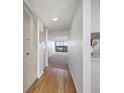 Bright hallway with hardwood floors leading to a living area with a view at 2900 Cove Cay Dr # 7C, Clearwater, FL 33760