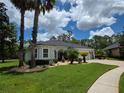Landscaped lawn featuring attractive tropical plants, a paved driveway, and neutral tones at 32015 Summerglade Dr, Wesley Chapel, FL 33545