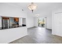Bright living area adjacent to the kitchen and featuring tile floors, a sliding glass door, and recessed lighting at 3300 Haviland Ct # 103, Palm Harbor, FL 34684