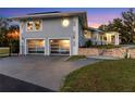 Exterior view of home featuring a modern, glass two-car garage and stone facade at 3425 W Forest Lake Cir, Sarasota, FL 34232