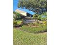 Well-maintained community sign surrounded by colorful flowers and greenery at 3536 Countrybrook Ln # 13, Palm Harbor, FL 34684