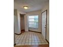 Tiled entryway with coat closet and front door offering natural light through a window at 3536 Countrybrook Ln # 13, Palm Harbor, FL 34684