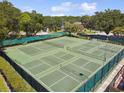 Aerial view of multiple tennis courts surrounded by lush landscaping, offering recreational opportunities at 3673 Fremantle Dr, Palm Harbor, FL 34684