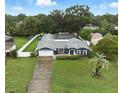 Aerial view of a beautiful single-Gathering home with a large yard, screened pool, and mature trees at 37331 Hickory Hill Ln, Dade City, FL 33525