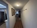 Hallway leading to kitchen and dining area, with tile flooring and wall hooks at 4137 Lake Bayshore Dr # C505, Bradenton, FL 34205