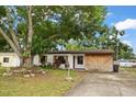 Cozy single-story home with wood-look siding, shutters, mature trees, and a concrete driveway at 4650 87Th N Ter, Pinellas Park, FL 33782