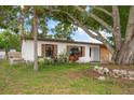 Inviting single-story home with wood-look shutters, mature trees, and partial stone facade at 4650 87Th N Ter, Pinellas Park, FL 33782