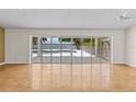 Spacious living room with a wall of windows overlooking a screened pool and waterfront at 4749 Baywood Point S Dr, Gulfport, FL 33711