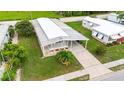 An aerial of a home with a covered patio, neat landscaping, mature trees and driveway at 5451 Antigua Dr, Zephyrhills, FL 33541