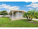 Well-maintained single-story house with a wide covered patio, neat landscaping, and mature trees at 5451 Antigua Dr, Zephyrhills, FL 33541