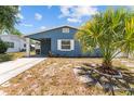 Charming blue home with a well-manicured yard and covered entrance at 546 90Th N Ave, St Petersburg, FL 33702