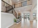 Grand foyer features a staircase with dark wood banisters and an open view to the formal sitting room at 6129 Marsh Trail Dr, Odessa, FL 33556