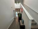 Inviting hallway with wood-look floors, a staircase, a fish tank and views into the living area at 7563 Ashcroft Dr, Wesley Chapel, FL 33545