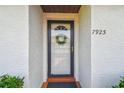 Close-up of a white front door with glass panel, decorative wreath, and the house number 7923 at 7923 Radcliffe Cir, Port Richey, FL 34668