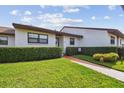 Charming single-story home with manicured lawn, tidy hedges, and a welcoming walkway to the front door at 7923 Radcliffe Cir, Port Richey, FL 34668