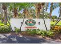 Harbor Greens entrance sign amidst lush greenery, marking a private residential community at 9461 Harbor Greens Way # 502, Seminole, FL 33776