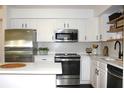 Bright kitchen with white cabinets, stainless steel appliances, and modern tile backsplash at 9481 Highland Oak Dr # 1310, Tampa, FL 33647