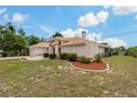 Attractive home with a tile roof, tidy landscaping, and a well-maintained lawn on a sunny day at 11411 Terrell, Spring Hill, FL 34606