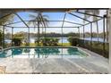 Relaxing screened pool with waterfront views and lush landscaping at 11613 Sunshine Pond Rd, Tampa, FL 33635