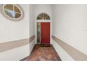 Inviting entryway with a red front door, brick flooring, and elegant architectural details at 12209 Glencliff Cir, Tampa, FL 33626