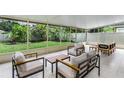Screened-in porch with comfortable seating, offering a relaxing outdoor space with views of the backyard at 12335 Glenfield Ave, Tampa, FL 33626